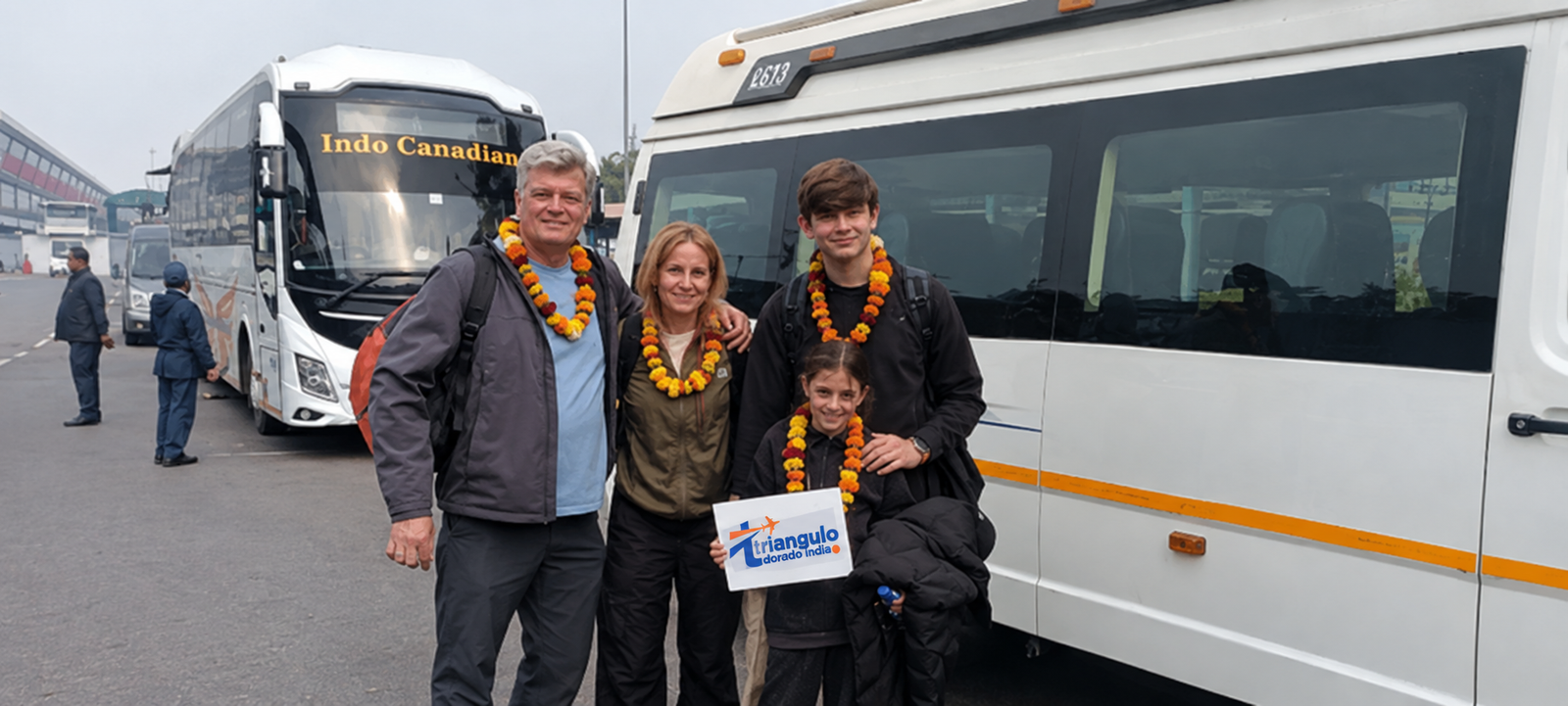 Familia recibida con guirnaldas de caléndula junto a una furgoneta Tempo Traveller a su llegada a Delhi, al inicio del Tour Del Triángulo Dorado Con Rishikesh