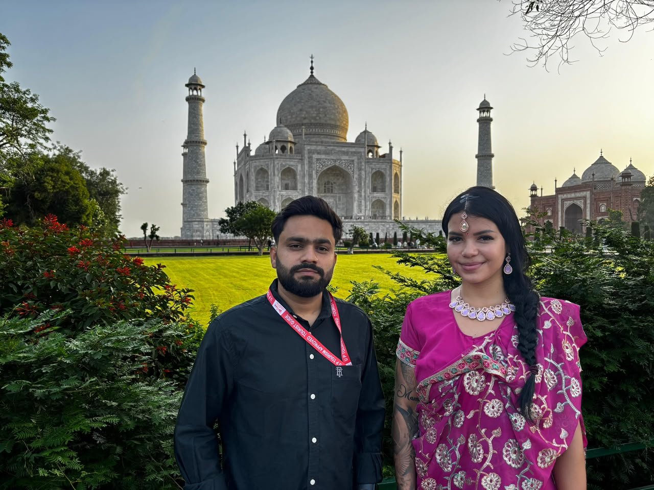 Tour al Taj Mahal en tren Gatimaan Express con guía turístico y visitantes frente al Taj Mahal en Agra, India.